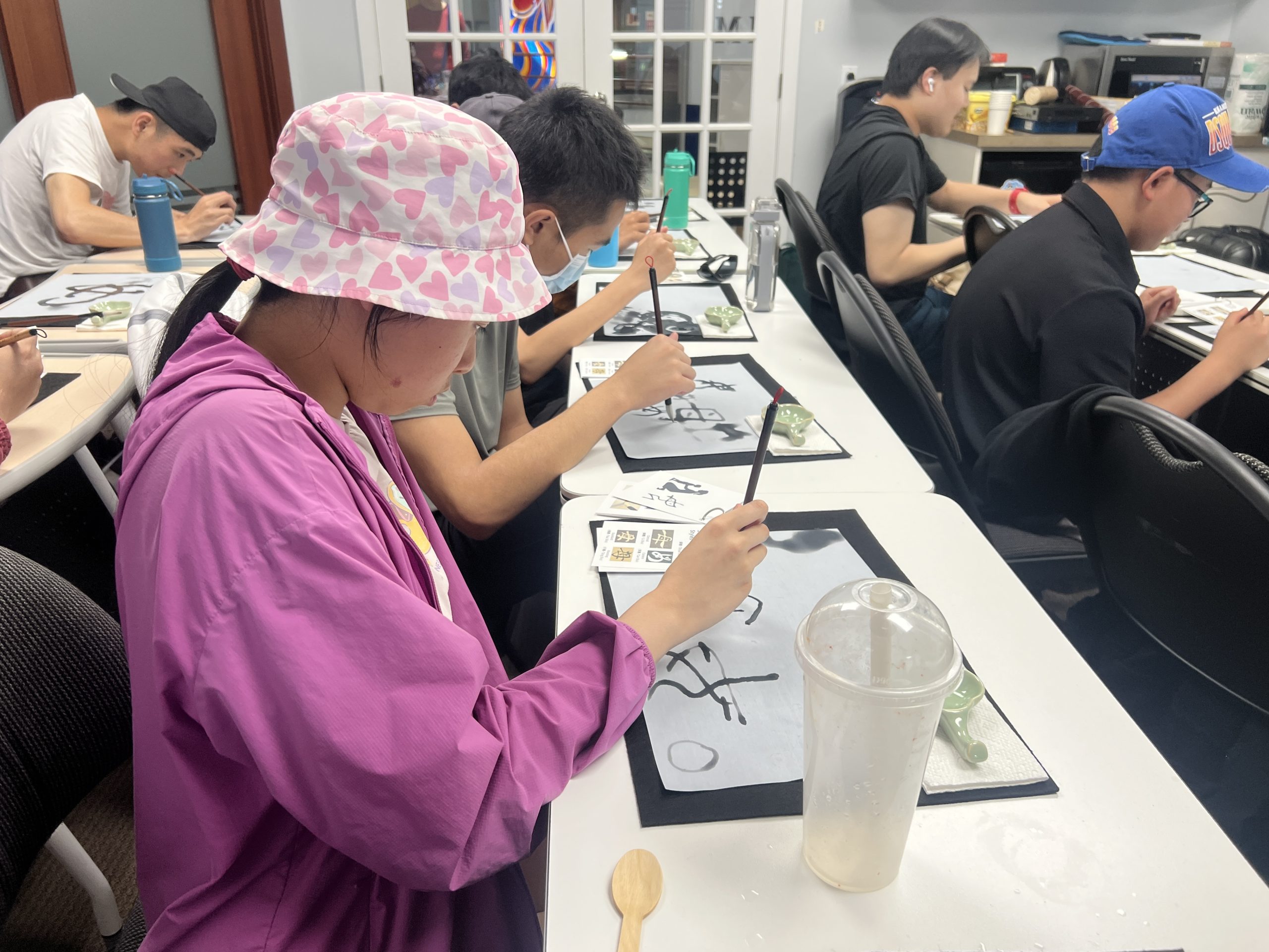 Young participant writing calligraphy with a brush
