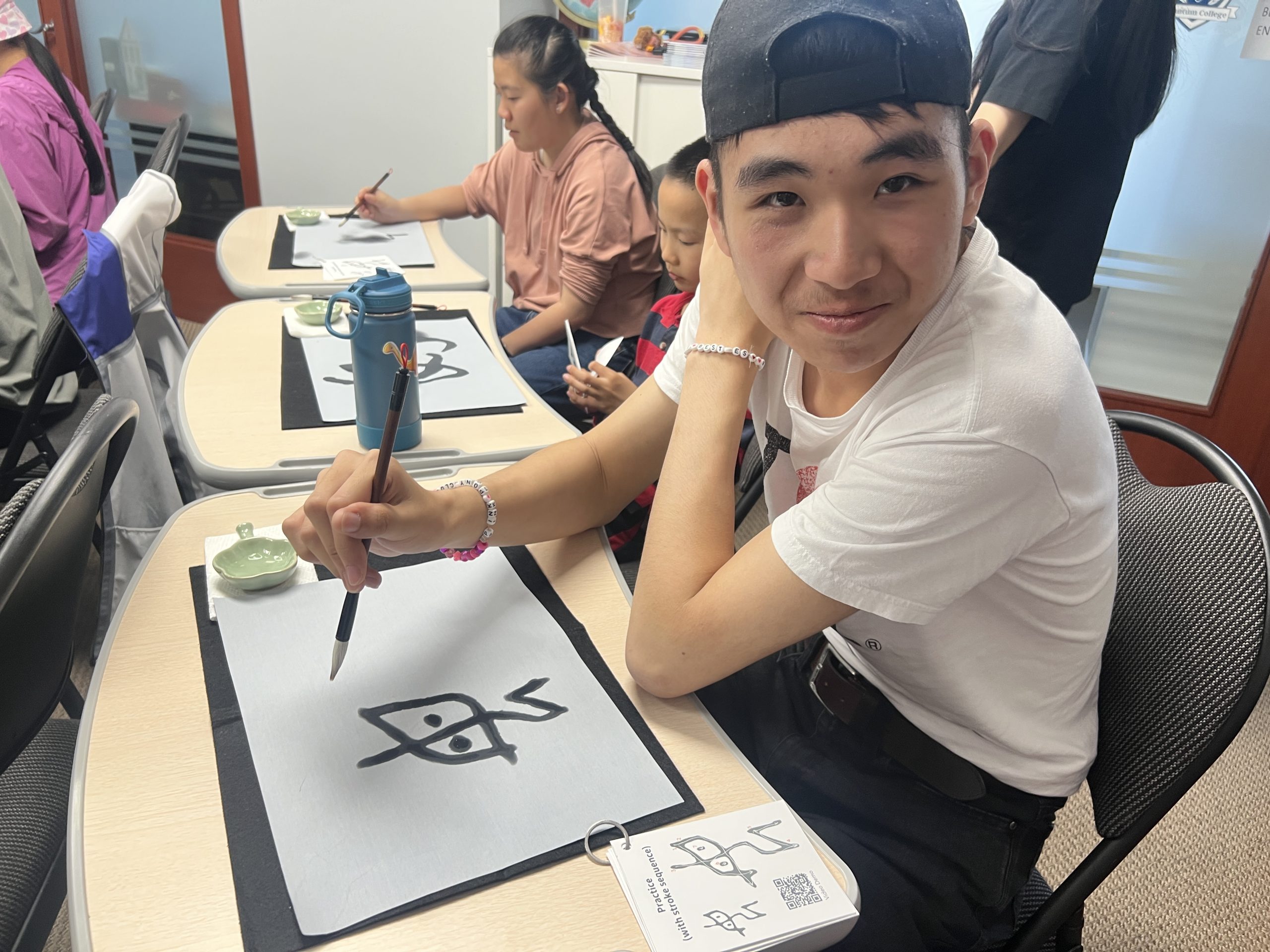 Workshop participant showing their calligraphy work